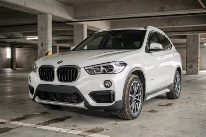 BMW X1 F48 blanc garé dans un parking urbain, vue trois quarts avant mettant en valeur la calandre et les jantes, illustration fiabilité SUV compact