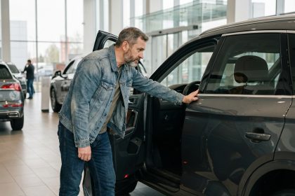 Homme d age moyen examine une SUV moderne en concession