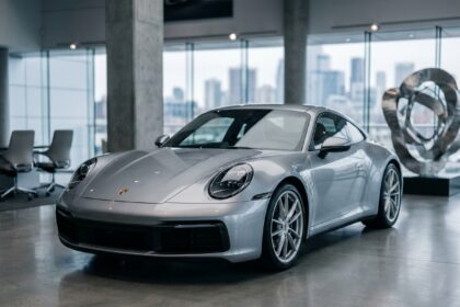 Porsche 911 Carrera argentée dans une concession automobile de luxe, illustration pour assurance voiture de prestige 2026